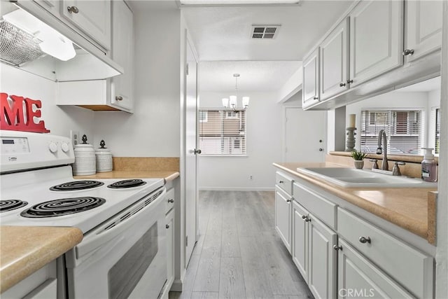 kitchen with white electric range oven, white cabinetry, sink, and light hardwood / wood-style flooring