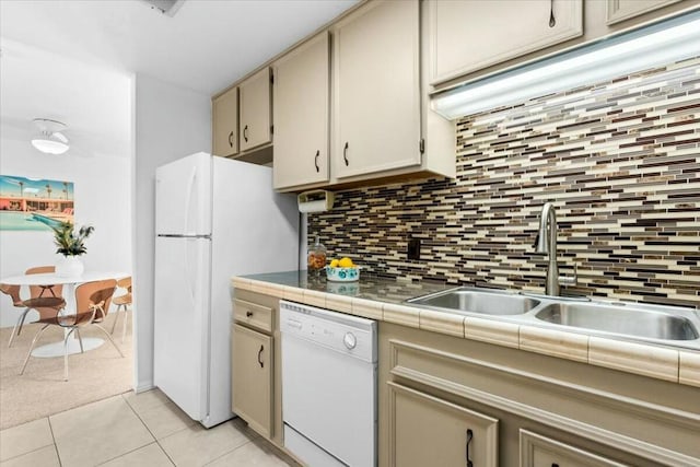 kitchen with white appliances, backsplash, sink, tile counters, and light tile patterned flooring