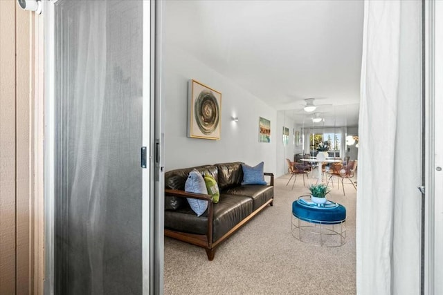 carpeted living room with ceiling fan