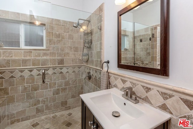 bathroom with vanity, a shower with shower door, and tile walls