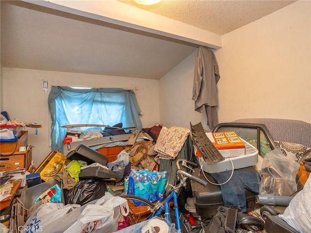 miscellaneous room featuring lofted ceiling and a textured ceiling