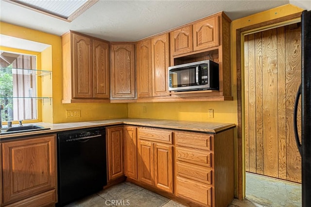 kitchen featuring light tile patterned floors, sink, and black appliances