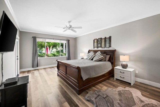 bedroom with ceiling fan, wood-type flooring, and crown molding