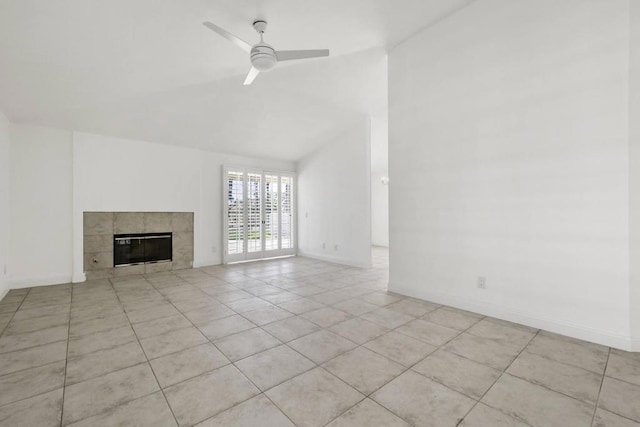 unfurnished living room with ceiling fan, light tile patterned floors, lofted ceiling, and a tiled fireplace