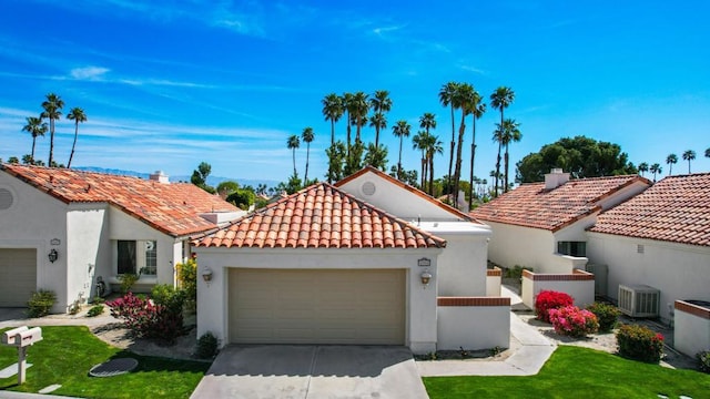 mediterranean / spanish home with a garage and central air condition unit