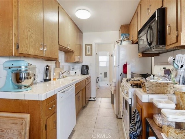 kitchen with backsplash, white appliances, sink, and light tile patterned floors