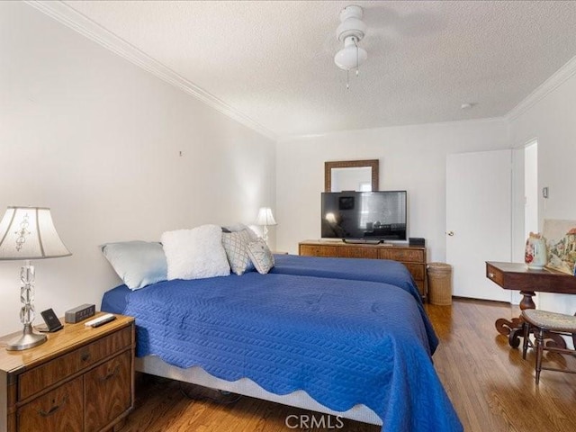 bedroom with a textured ceiling, ceiling fan, crown molding, and dark wood-type flooring