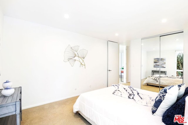 bedroom featuring light carpet and a closet