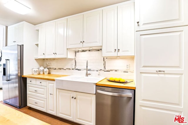 kitchen featuring sink, white cabinets, butcher block counters, and stainless steel appliances