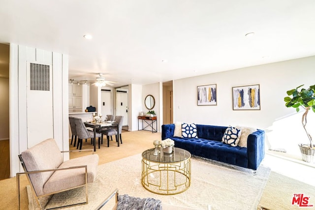 carpeted living room with ceiling fan