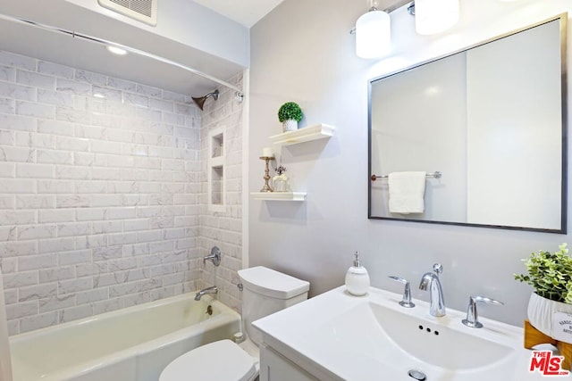 full bathroom featuring toilet, tiled shower / bath, and vanity