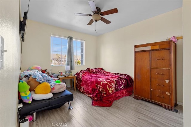 bedroom with light hardwood / wood-style flooring and ceiling fan