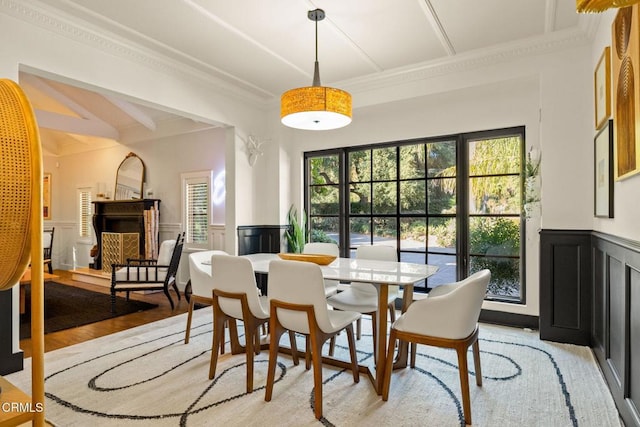 dining space with light wood-type flooring and crown molding