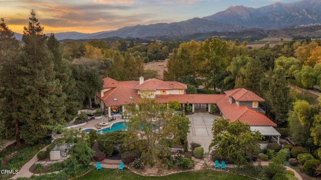 aerial view at dusk featuring a mountain view