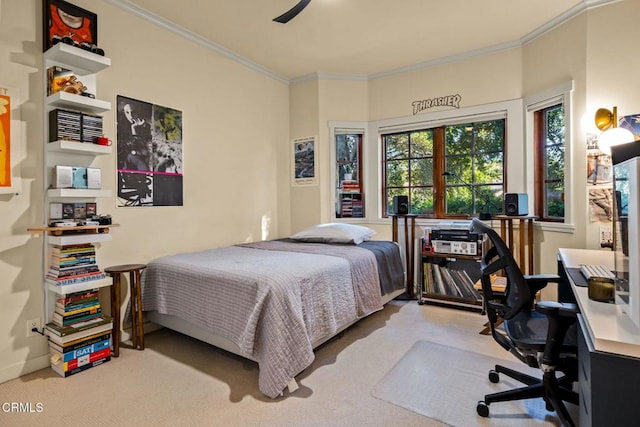 carpeted bedroom featuring ceiling fan and crown molding