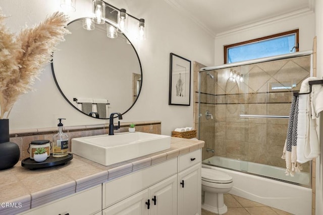 full bathroom featuring vanity, shower / bath combination with glass door, crown molding, tile patterned flooring, and toilet