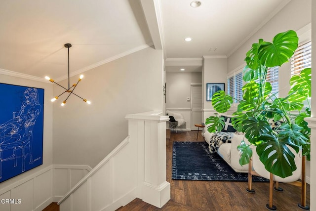 hallway featuring dark wood-type flooring, an inviting chandelier, and crown molding