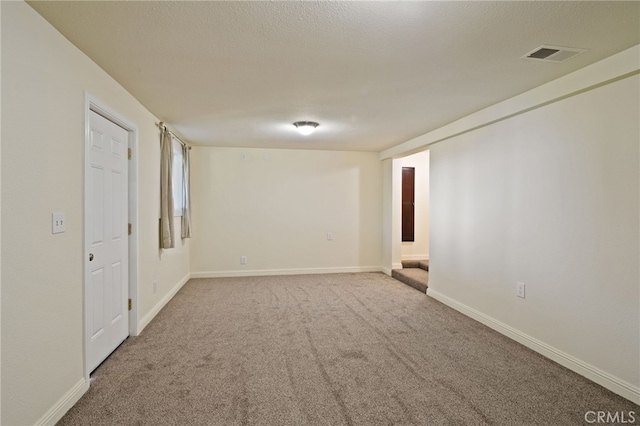 empty room with a textured ceiling and carpet flooring