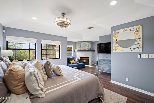 bedroom featuring a fireplace and dark wood-type flooring