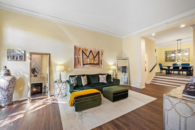 living room with dark hardwood / wood-style floors, crown molding, and an inviting chandelier