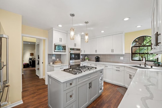 kitchen with light stone countertops, white cabinetry, dark wood-type flooring, and appliances with stainless steel finishes