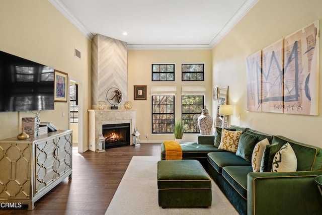 living room with dark hardwood / wood-style floors, a large fireplace, and crown molding