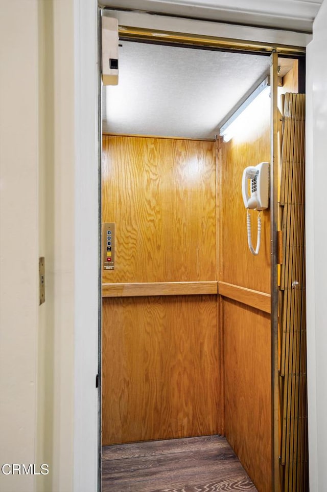 room details featuring elevator and wood-type flooring