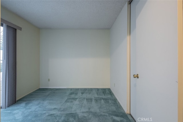 unfurnished room featuring carpet flooring and a textured ceiling