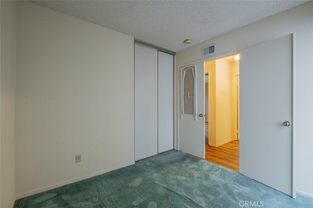 unfurnished bedroom with carpet, a textured ceiling, and a closet