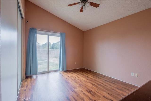 unfurnished room with a textured ceiling, ceiling fan, lofted ceiling, and light wood-type flooring