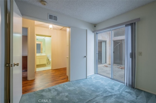 unfurnished bedroom featuring wood-type flooring, a textured ceiling, and a closet