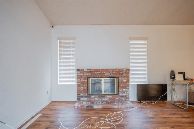 living room with a fireplace, hardwood / wood-style floors, and lofted ceiling