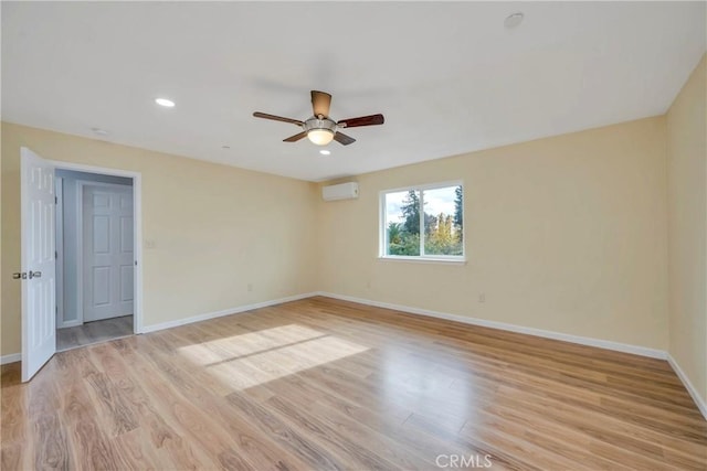 unfurnished room with ceiling fan, light hardwood / wood-style floors, and an AC wall unit