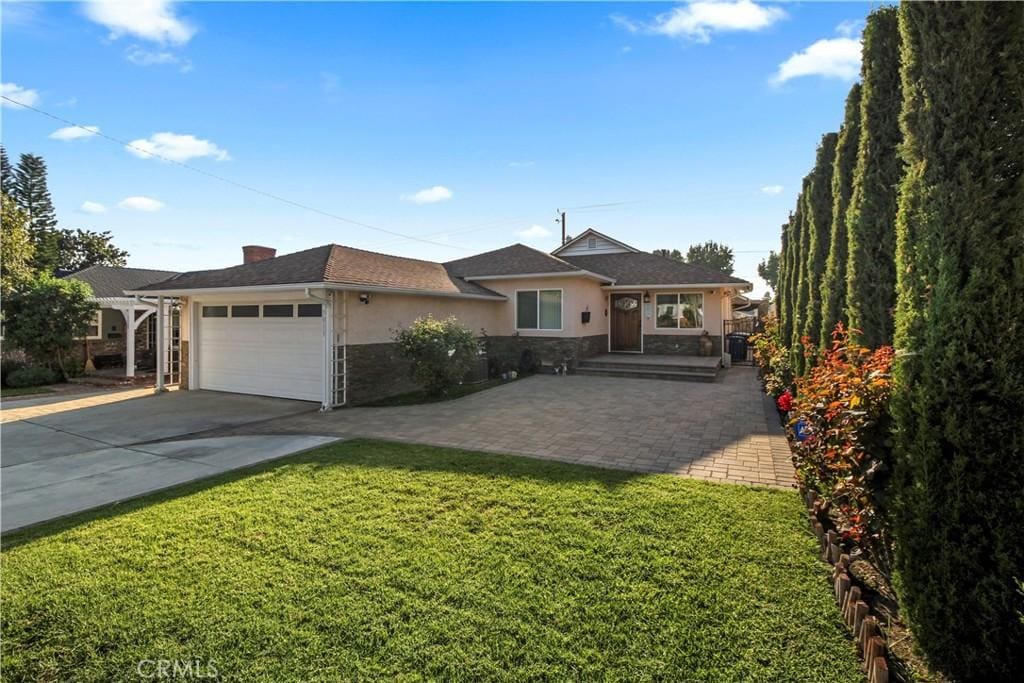 ranch-style home with a garage and a front lawn