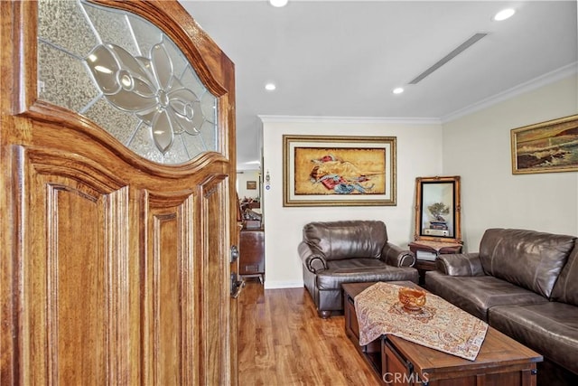 living room with wood-type flooring and crown molding