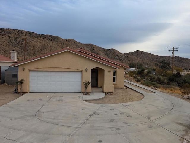 view of front of home with a mountain view and a garage