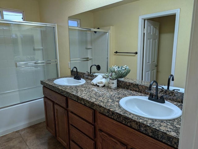 bathroom featuring tile patterned flooring, vanity, and combined bath / shower with glass door