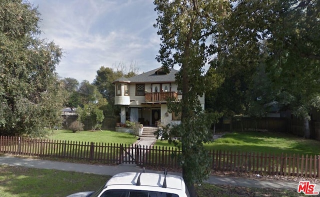 view of front of home featuring a balcony and a front yard