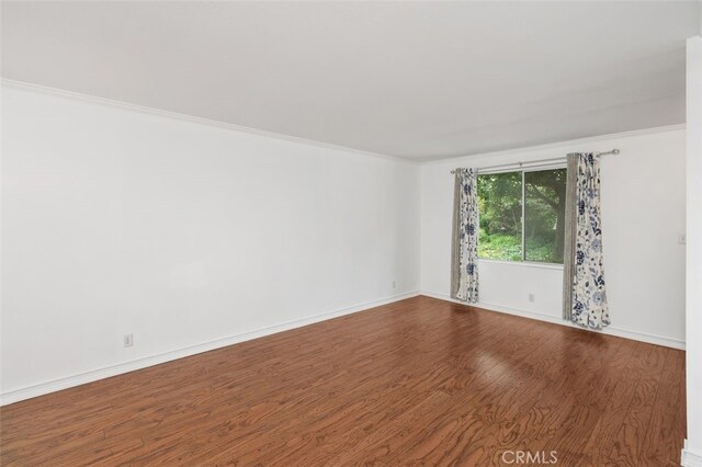 spare room featuring hardwood / wood-style floors and ornamental molding