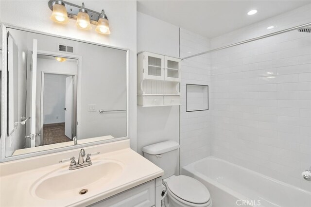 full bathroom with vanity, toilet, and tiled shower / bath combo