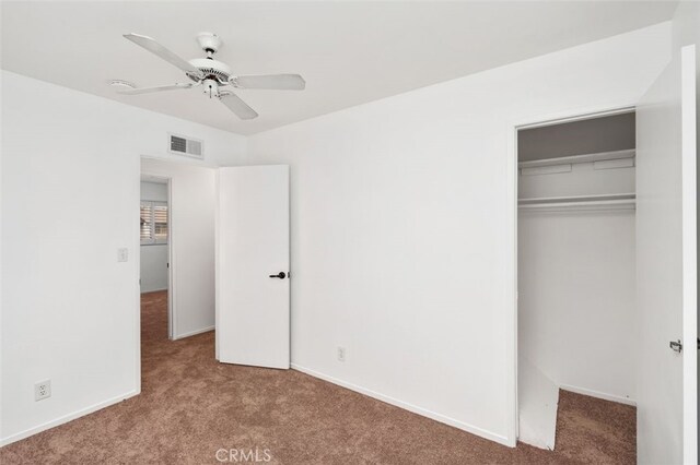 unfurnished bedroom featuring light carpet, a closet, and ceiling fan