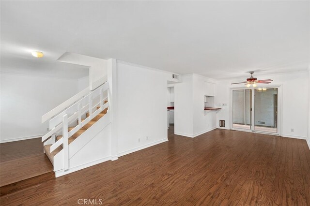 unfurnished living room with dark hardwood / wood-style flooring and ceiling fan