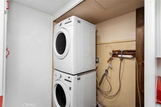 washroom with stacked washing maching and dryer