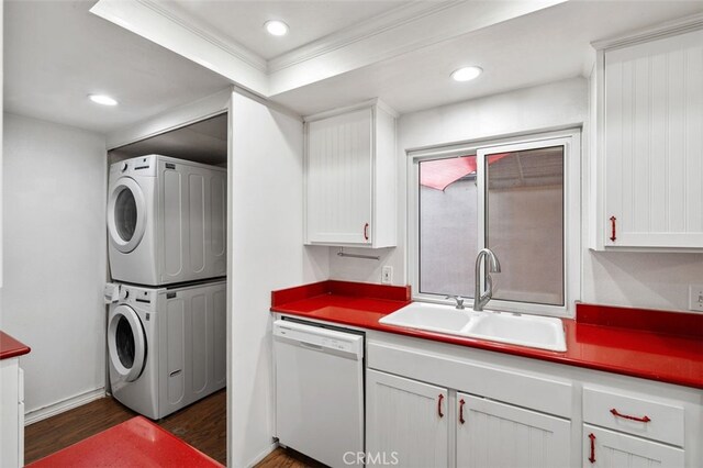 laundry room with dark hardwood / wood-style flooring, stacked washing maching and dryer, ornamental molding, and sink