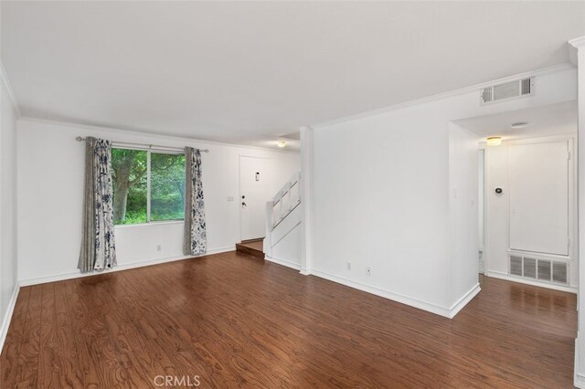 spare room featuring dark hardwood / wood-style flooring and crown molding