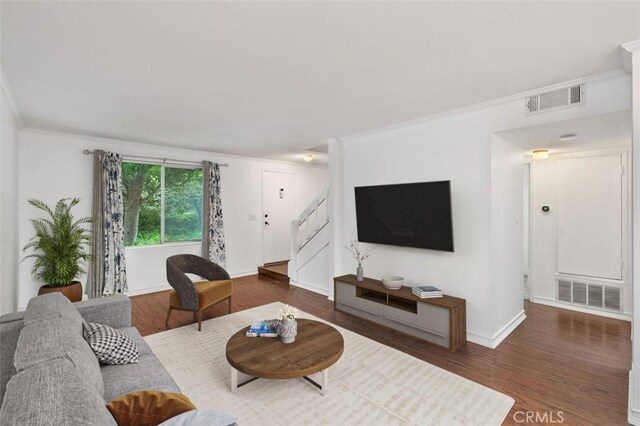 living room with dark hardwood / wood-style floors and crown molding