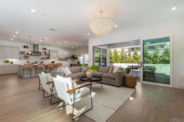 living room with light hardwood / wood-style floors and an inviting chandelier