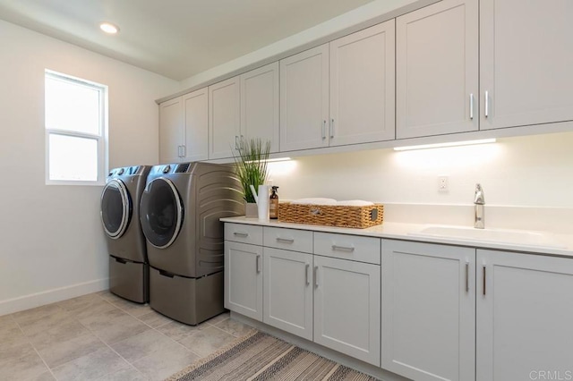 clothes washing area featuring cabinets, separate washer and dryer, and sink