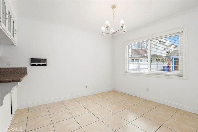 unfurnished dining area featuring light tile patterned flooring, crown molding, and an inviting chandelier