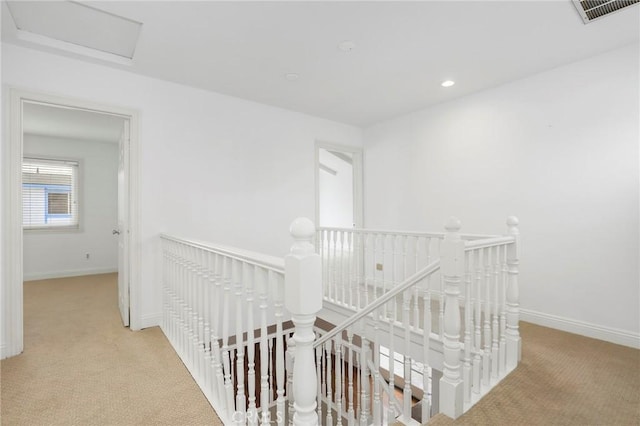 hall featuring light colored carpet